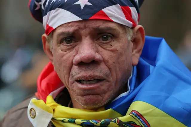 رجل من فنزويلا يرتدي العلم الأمريكي والعلم الفنزويلي أمام محكمة دانيال باتريك موينيهان الفيدرالية قبل جلسة استماع الرئيس الفنزويلي نيكولاس مادورو والسيدة الأولى سيليا فلوريس في 5 يناير 2026 في مدينة نيويورك.