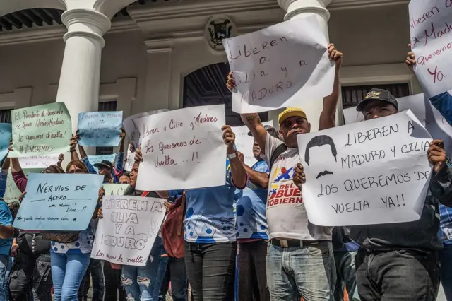 رفع أنصار الرئيس الفنزويلي المخلوع نيكولاس مادورو لافتات خلال مظاهرة أثناء مشاهدتهم جلسة للجمعية الوطنية على شاشة كبيرة في ماراكايبو، فنزويلا، في 5 يناير/كانون الثاني 2026.