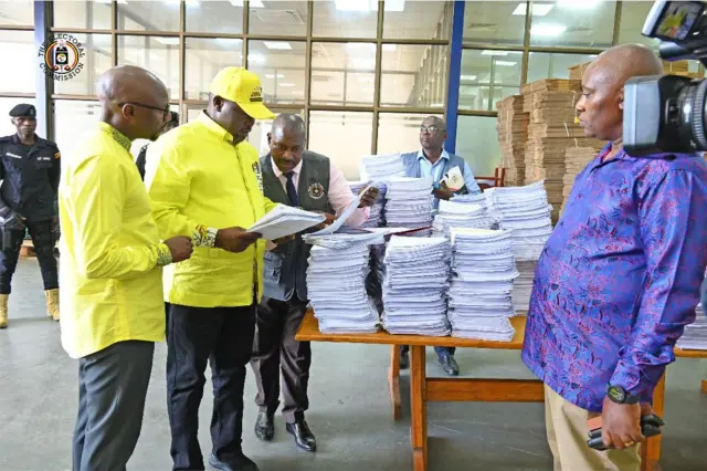 Maafisa wa Tume ya Uchaguzi Uganda wakikabidhi maajenti wa wagombea urais daftari la wapiga kura ili kutathmini kabla ya uchaguzi mkuu wiki ijayo.
