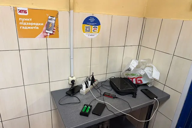 Жители Кривого Рога подзаряжают свои устройства в одном из супермаркетов.