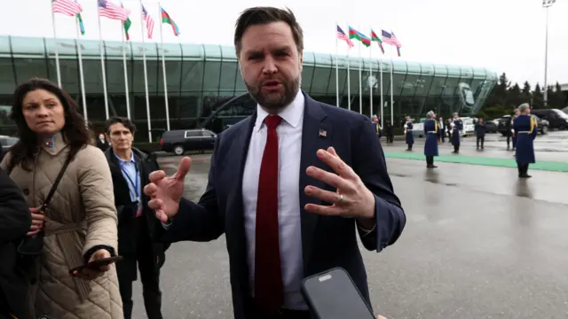 جی دی ونس با کت آبی، پیراهن سفید و کراوات قرمز در حال گفت‌وگوی خبری