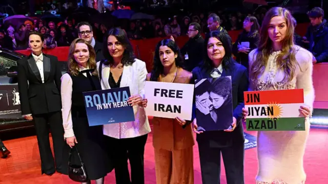 بازیگران و فعالان سیاسی با پلاکارد زن زندگی آزادی و تصویر کشته‌های اعتراضات اخیر ایران در افتتاحیه جشنواره فیلم برلین