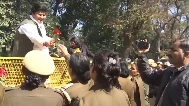 ओम बिरला से नहीं मिल पाने के कारण सुरक्षाकर्मियों को फूल देतीं कांग्रेस कार्यकर्ता