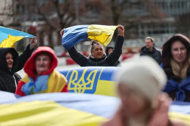 женщина держит над головой флаг Украины