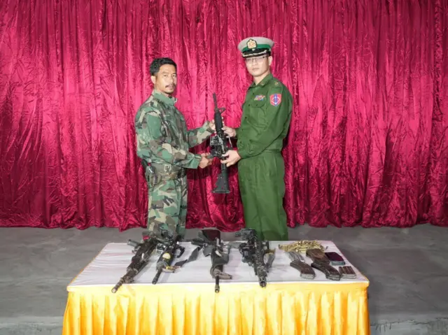 လက်နက်တွေလွှဲနေတဲ့ပုံစံနဲ့မြင်ရတဲ့ ဗိုလ်နဂါးနဲ့ စစ်တပ်အရာရှိတစ်ဦး