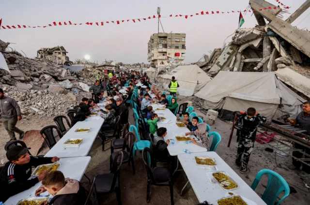 فلسطينيون تجمعوا لتناول وجبة الإفطار في أول أيام شهر رمضان في مدينة غزة، وسط ركام أبنية مهدمة