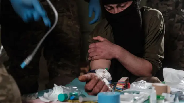 Люди в камуфляже изучают содержимое аптечки