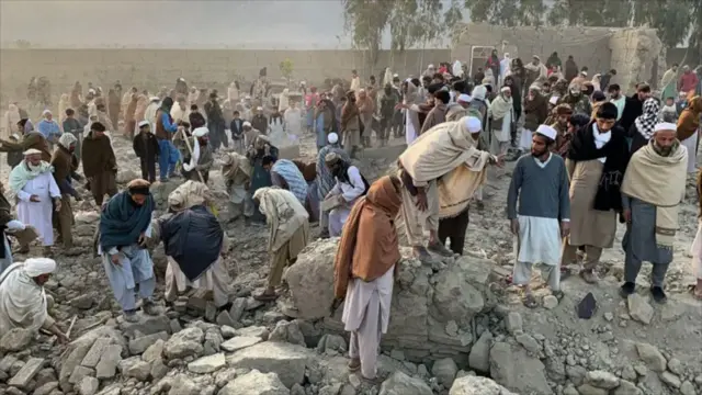 مردم در جریان عملیات جستجو در محل حمله هوایی جمع شده‌اند