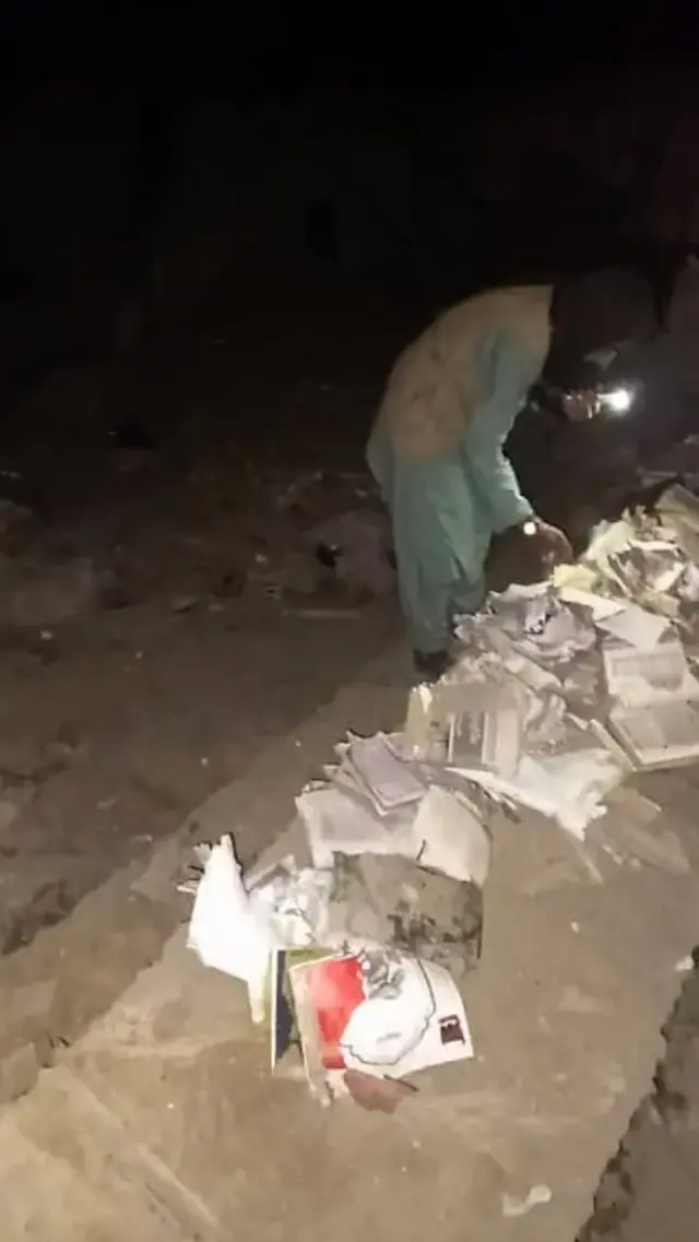 فردی در کنار کتاب‌های تخریب شده