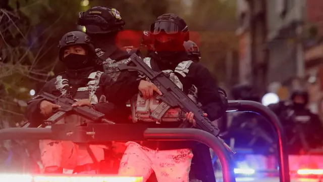 imagen de dos policías mexicanos con armas largas en un vehículo