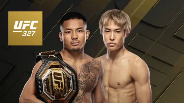 Flyweight ချန်ပီယံခါးပတ်ကို ပခုံးပေါ် တင်ထားတဲ့ ဂျော့ရှုဝါ ဗန်နဲ့ တာဆုရို တိုင်ရာတို့ကို ကင်မရာကြည့်နေတဲ့ အနေအထားနဲ့ပြသထားတဲ့ UFC ဓာတ်ပုံ