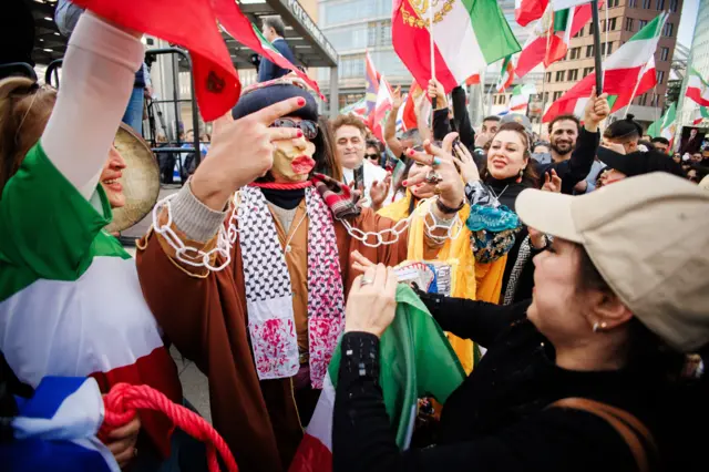 Manifestantes bailan durante una manifestación de iraníes exiliados en la plaza Potsdamer Platz de Berlín, Alemania