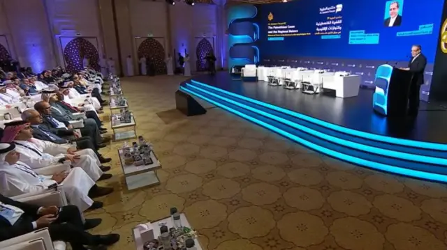 عباس عراقچی در حال سخنرانی در مجمه الجزیره