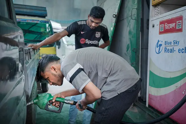 ঢাকার একটি পেট্রোল পাম্পে একটি যানবাহনে জ্বালানি নিচ্ছেন এক ব্যক্তি।
