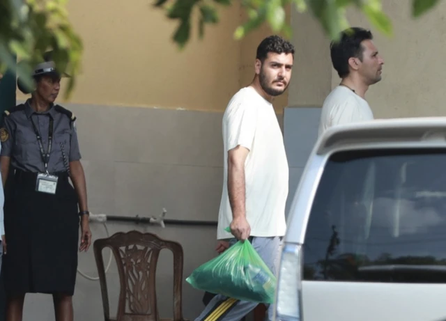 Beyaz tişörtlü bir İranlı yürüyor, elindeki torbada askeri üniforması olduğum anlaşılıyor