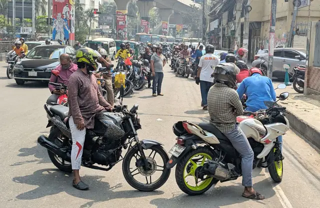 মধ্যপ্রাচ্যে যুদ্ধের কারণে বৈশ্বিক জ্বালানি সরবরাহে বিঘ্ন হয়েছে, এই ধাক্কা পড়েছে বাংলাদেশেও। জ্বলানি সংকট হতে পারে, এমন আশঙ্কার কারণে ঢাকার বিভিন্ন পেট্রল পাম্পে গাড়ি ও মোটর সাইকেলের দীর্ঘ লাইন দেখা যাচ্ছে। এই ছবিতেও দেখা যাচ্ছে যে তেল কিনতে মোটরসাইকেল ও ব্যক্তিগত গাড়ির চালকরা ঠাঁয় দাঁড়িয়ে আছেন।