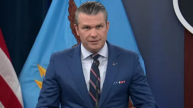 Hegseth mavi ceketiyle Pentagon'dan konuşuyor.
