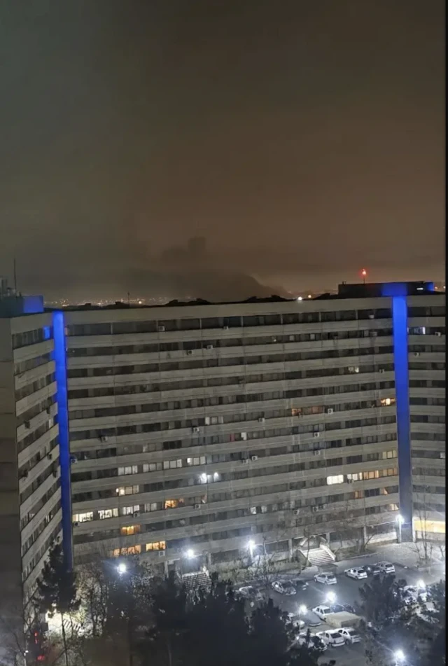 عکس شهرک اکباتان تهران در شب. نور انفجارهای شدید در دور دست پیدا است