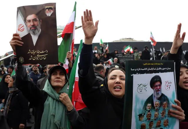 إيرانيات يرفعن صوراً للمرشد الأعلى الإيراني الجديد آية الله مجتبى خامنئي خلال جنازة جماعية لقادة الحرس الثوري الإيراني وقادة الجيش وغيرهم من الضحايا الذين سقطوا خلال الحرب في طهران، في 11 مارس/آذار 2026