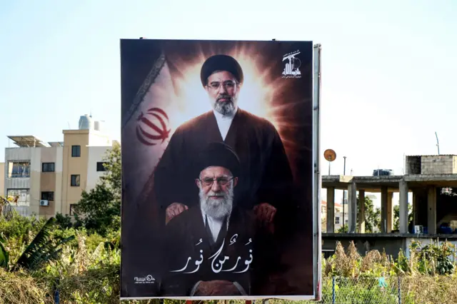 صورة للمرشد الإيراني الأعلى الجديد مجتبى خامنئي يقف فيها خلف والده