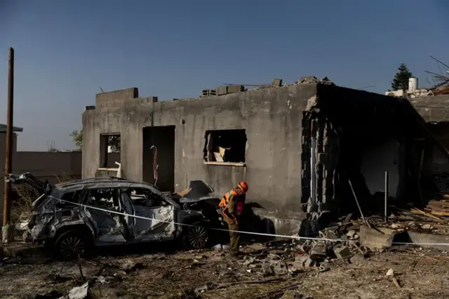 Umwe mu bakozi b'ubutabazi bariko baragenzura inzu yasambuwe mu gisagara ca Zarzir hafi y'igisagara ca Nazareti