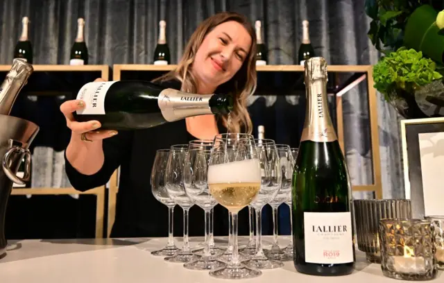 Una mujer sirve copas de champán en la cena de los Oscar