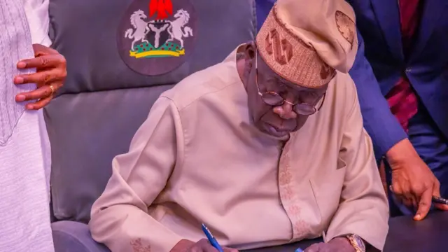 Foto Onyeisiala Tinubu oge ọ na-ebinye aka n'akwụkwọ
