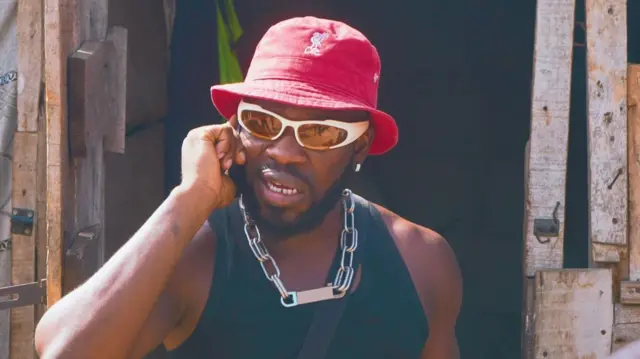 Broda Shaggi yi uwe na-eji oji, kpuru okpu mmemme na ughegbe anya na ọla olu na-aza ekwentị