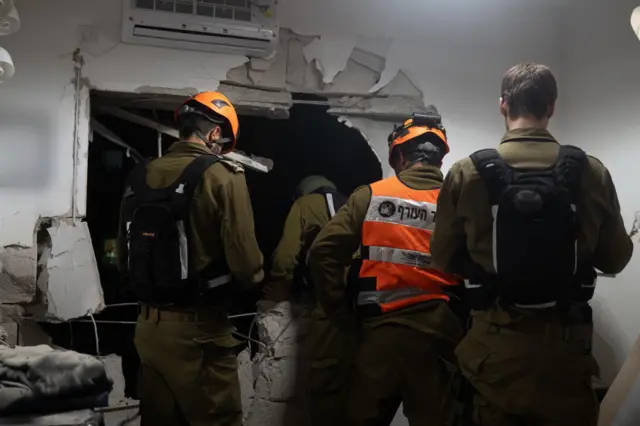 Сотрудники экстренных служб на месте попадания в центре Израиля