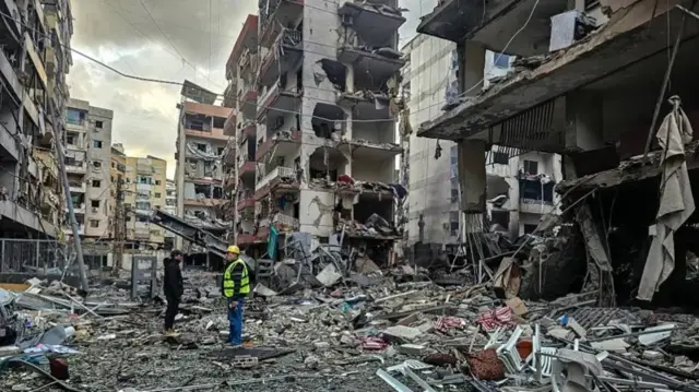 Men inspect a site of overnight Israeli airstrikes in the southern suburbs of Beirut