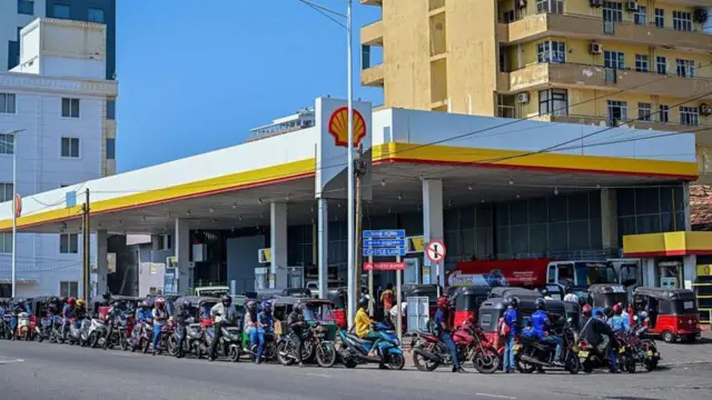 Người dân xếp hàng chờ đổ nhiên liệu cho phương tiện tại một trạm xăng ở Wellawatte, ngoại ô thủ đô Colombo của Sri Lanka