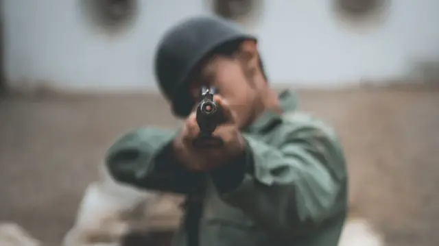 Umugabo urimo kurasa imbunda