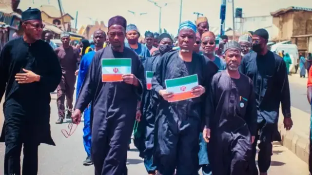 Ndị otu Shia yi uwe ojii jiri ọkọlọtọ mba Ịran n'aka na-eme ngagharịiwe