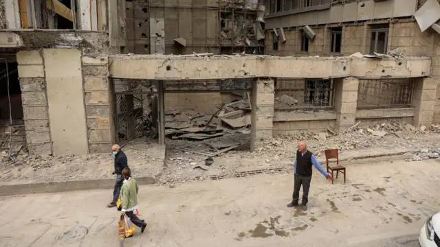 دو شهروند با کیسههای خرید از کنار ورودی بیمارستان گاندی تهران عبور میکنند