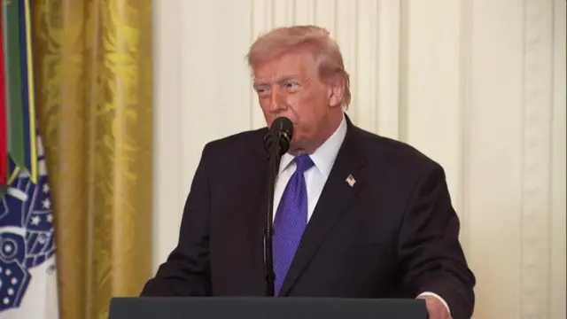 Donald Trump habla al micrófono detrás de un atril