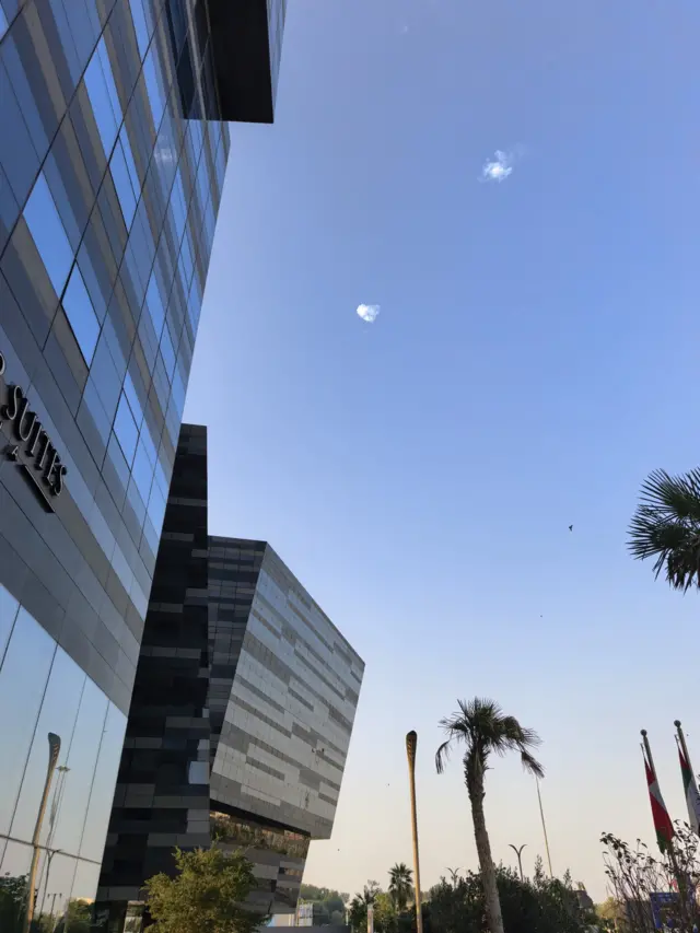 Вспышки в небе на фоне пальм и отеля.