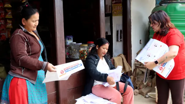 किमाथाङ्काकामा मतदान गर्ने तरिका सिकाउँदै एक स्वयंसेविका