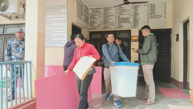 मतदानकेन्द्रतिर लग्न ग्विराटनगरमा मतदानका लागि आवश्यक सामग्रीसहित कर्मचारीहरू