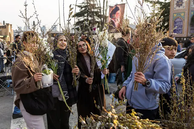 Люди покупают цветы на рынке в преддверии празднования Навруза, 19 марта