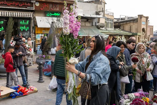 Люди совершают покупки на рынке в преддверии празднования Навруза 19 марта