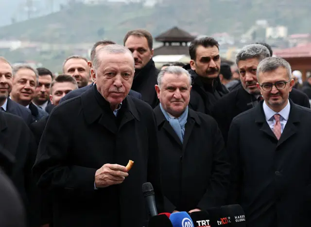 Cumhurbaşkanı Erdoğan Rize'de konuşma yapıyor. Elinde bayram simidi var.