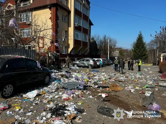 Разбросанный мусор около многоэтажного здания.