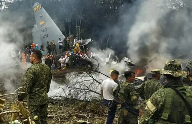 Abasirikare n'abantu basanzwe baboneka ahari ibisigarira vy'indege yakorotse.