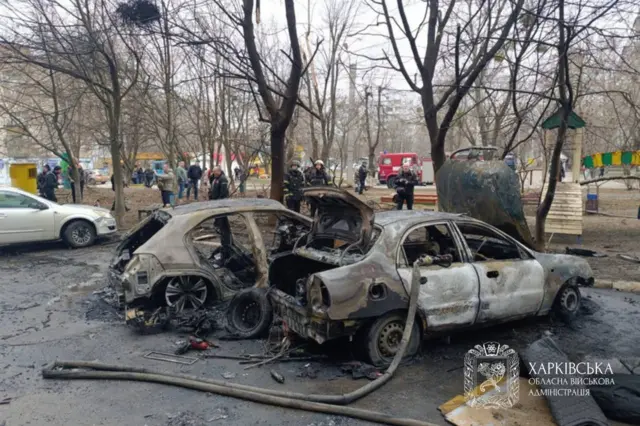 сгоревшие в результате попадания дрона автомашины во дворе многоэтажки в Харькове