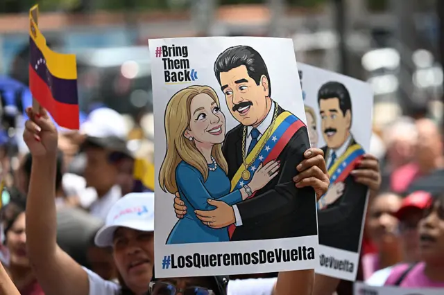 Manifestantes con banderas de Venezuela y carteles de la caricatura de Maduro y Flores junto con la consigna "los queremos de vuelta".