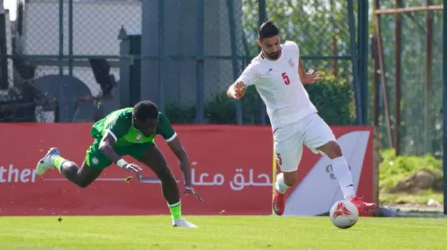 بازیکن ایران با لباس سفید و بازیکن نیجریه با لباس سبز