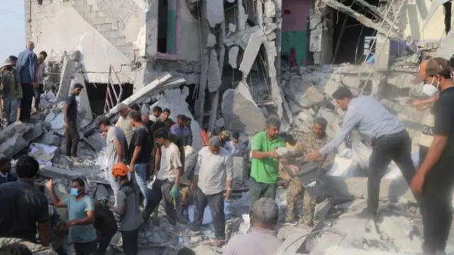 ከፍርስራሽ ውስጥ ሰዎችን ለማውጣት የሚሞክሩ ሰዎች