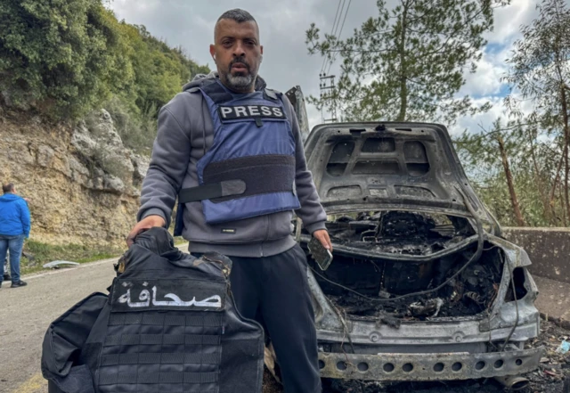 جلیقه ضد گلوله یک خبرنگار در دست یک خبرنگار دیگر در جنوب لبنان