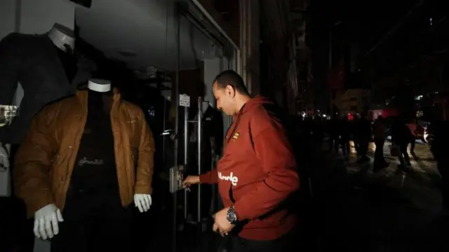 বন্ধ দোকানের সামনে এক ব্যক্তি।