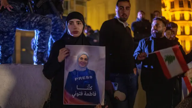 فتاة لبنانية تحمل صورة الصحفية فاطمة الفتوني.